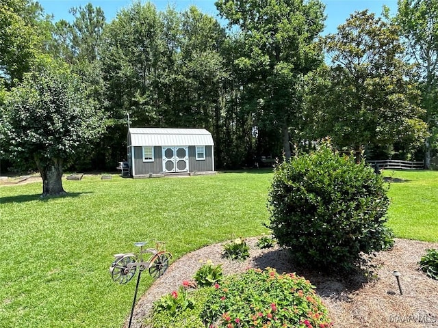 view of yard with an outbuilding, a storage unit, and fence