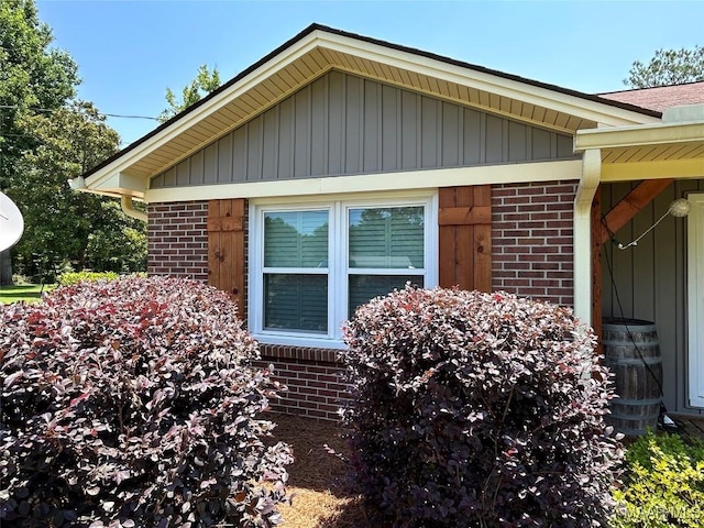 view of side of home featuring brick siding and board and batten siding