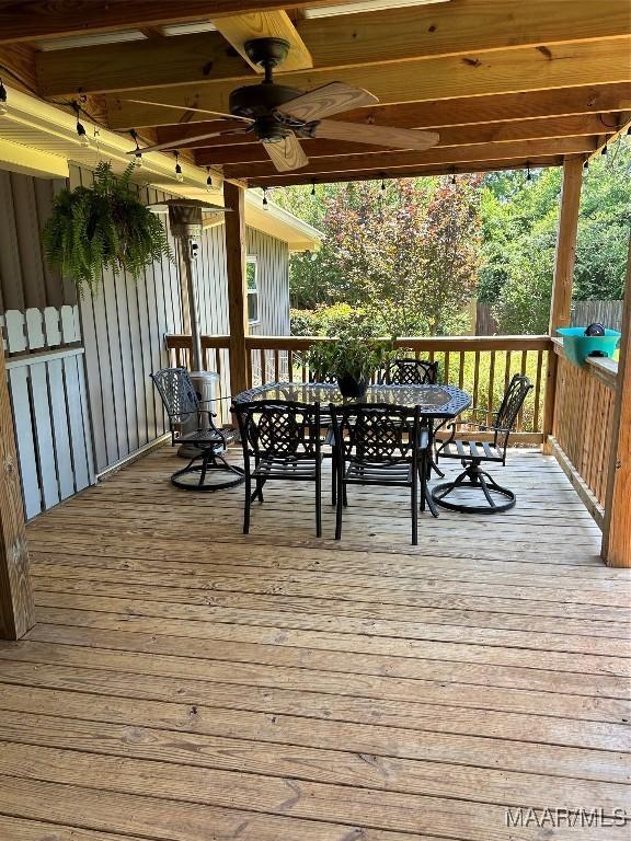 wooden deck featuring outdoor dining space and ceiling fan