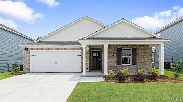 3140 Knotts Dr, Montgomery, AL 36116 - view of front of home featuring board and batten siding, a front lawn, brick siding, concrete driveway, and a garage