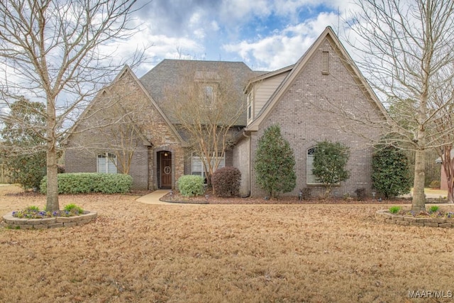 view of front of house featuring brick siding and a front yard