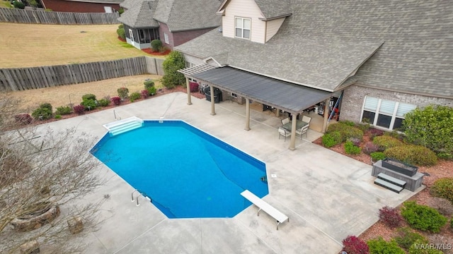 view of pool featuring a patio, a fenced in pool, a fenced backyard, a diving board, and a lawn