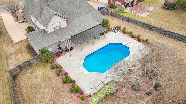 view of pool featuring a fenced in pool, a trampoline, a fenced backyard, and a patio area