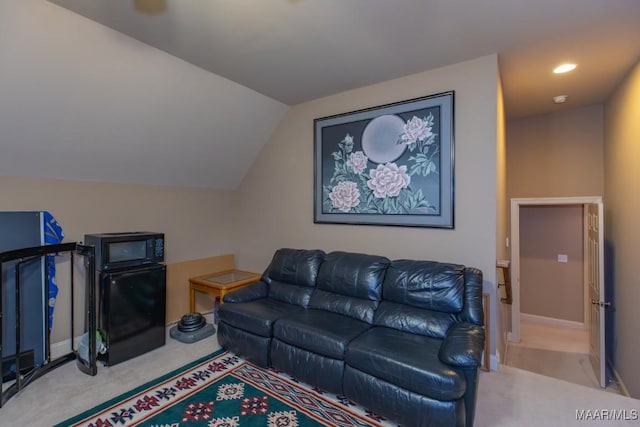 carpeted living room featuring baseboards and lofted ceiling