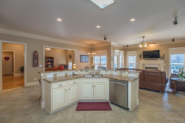 kitchen featuring a sink, stainless steel dishwasher, open floor plan, a fireplace, and crown molding