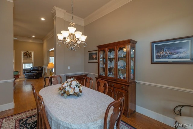 dining area featuring wood finished floors, baseboards, an inviting chandelier, recessed lighting, and crown molding