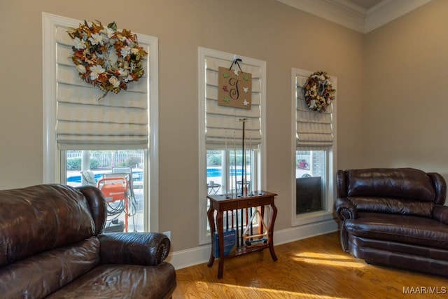 interior space with a wealth of natural light, wood finished floors, baseboards, and ornamental molding