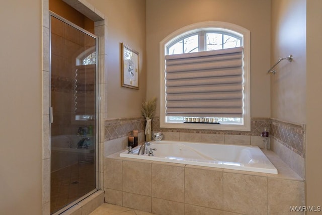 full bathroom with a shower stall, a bath, and tile patterned floors