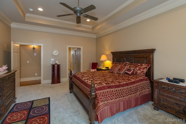 bedroom with light carpet, baseboards, a tray ceiling, and ornamental molding