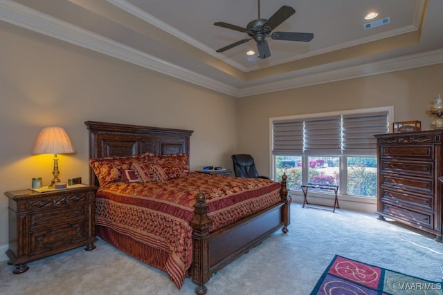 bedroom featuring visible vents, a ceiling fan, a tray ceiling, carpet flooring, and crown molding