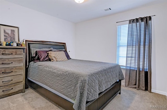 carpeted bedroom featuring baseboards and visible vents