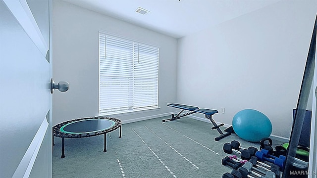 exercise room with visible vents and baseboards