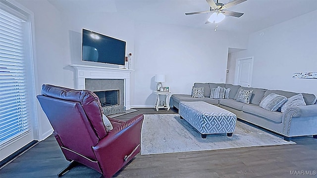 living area featuring a fireplace, a ceiling fan, and wood finished floors