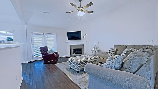 living area featuring baseboards, visible vents, a fireplace, dark wood-style flooring, and ceiling fan