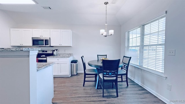 kitchen with wood finished floors, a notable chandelier, appliances with stainless steel finishes, and white cabinets