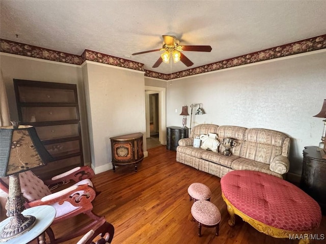 living room with baseboards, a textured ceiling, wood finished floors, and a ceiling fan