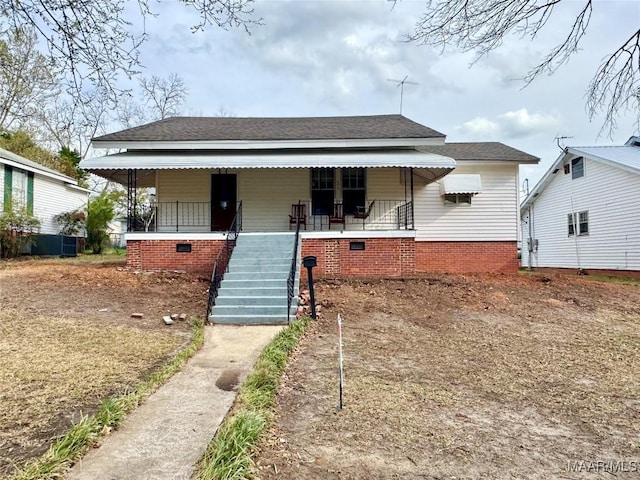 view of front of house with roof with shingles, a porch, and stairs