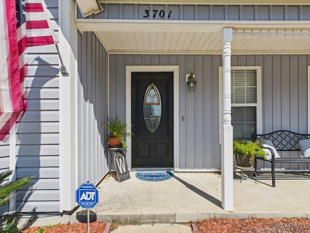 view of exterior entry featuring board and batten siding and a porch