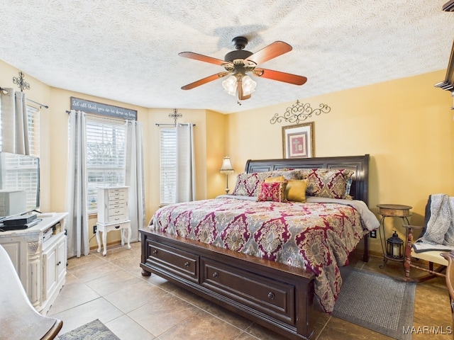 bedroom featuring light tile patterned floors, a textured ceiling, and ceiling fan