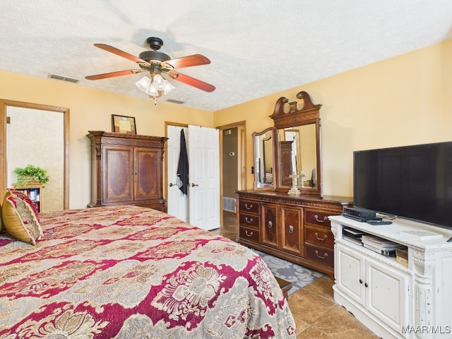 bedroom with visible vents, a textured ceiling, and ceiling fan