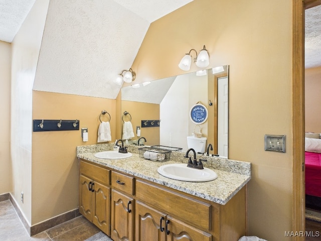 ensuite bathroom with double vanity, vaulted ceiling, ensuite bath, and a sink