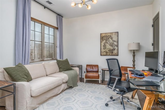 office space featuring visible vents, wood finished floors, baseboards, and a chandelier