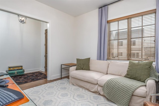 living area with baseboards and wood finished floors