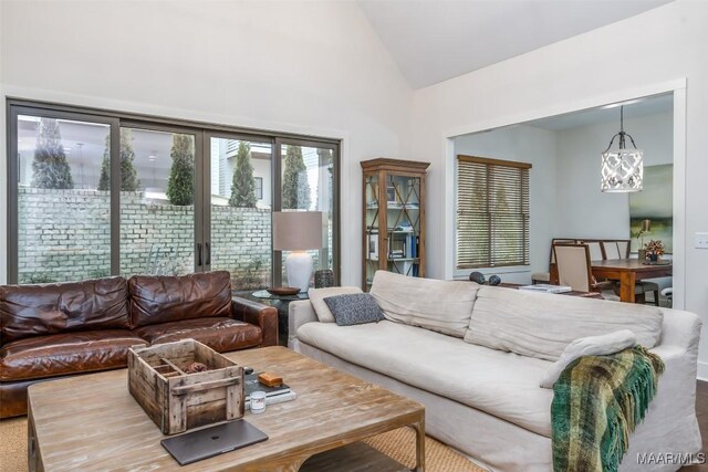 living room featuring a notable chandelier and high vaulted ceiling