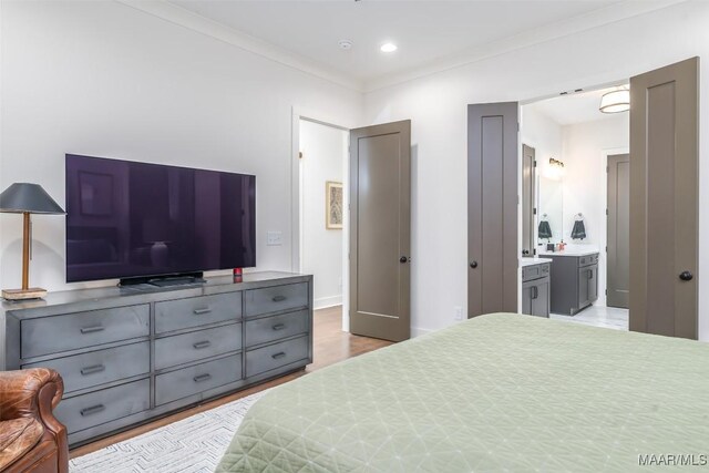 bedroom featuring ornamental molding, wood finished floors, recessed lighting, connected bathroom, and baseboards