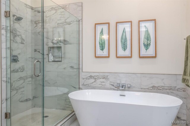 bathroom featuring a freestanding bath, tile walls, and a stall shower