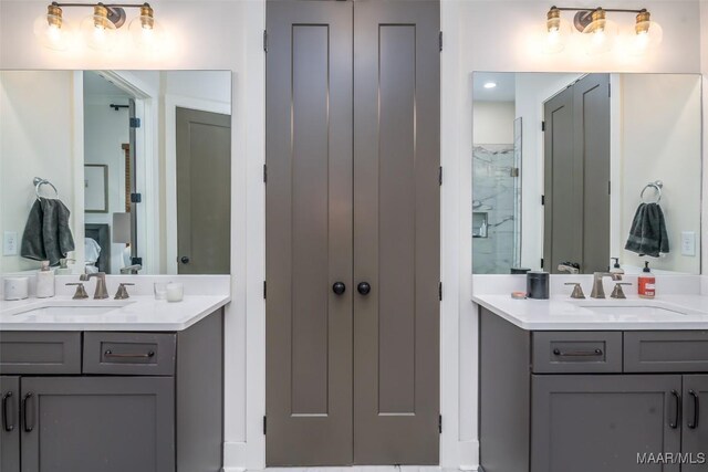 full bath with a shower stall, two vanities, and a sink