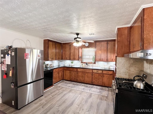 kitchen with visible vents, light wood-style flooring, ceiling fan, appliances with stainless steel finishes, and brown cabinets