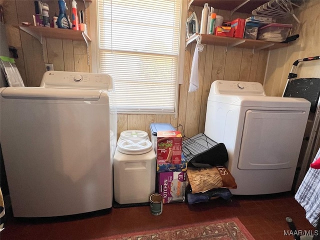 washroom featuring wood walls, wood finished floors, washer and dryer, and laundry area