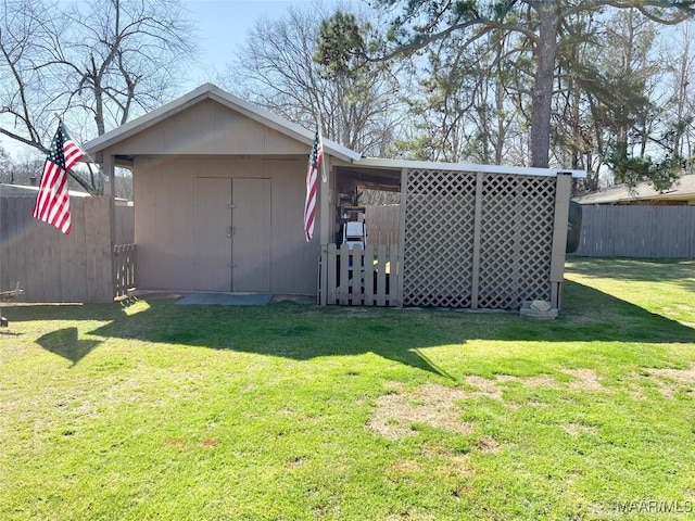 view of yard featuring a storage unit, an outbuilding, and fence