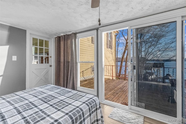 bedroom featuring multiple windows, a textured ceiling, and wood finished floors