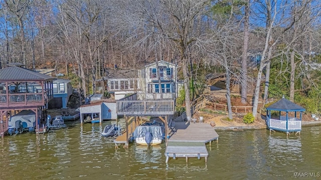 dock area featuring a gazebo and a deck with water view