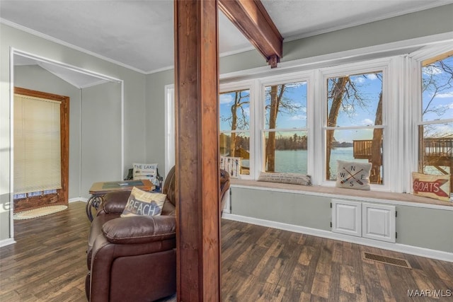 living area with visible vents, baseboards, dark wood finished floors, and crown molding