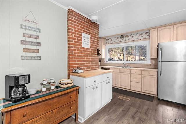 kitchen featuring light brown cabinets, butcher block counters, freestanding refrigerator, and dark wood-type flooring