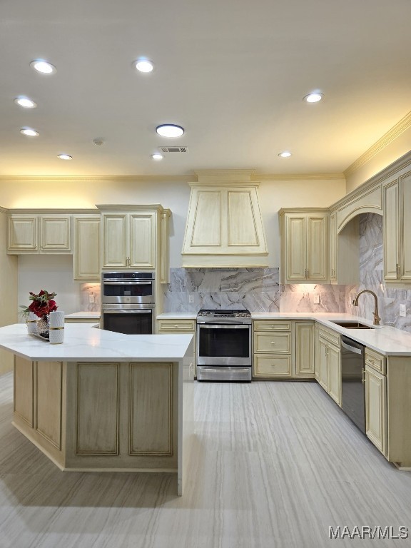 kitchen featuring visible vents, premium range hood, a sink, stainless steel appliances, and light countertops