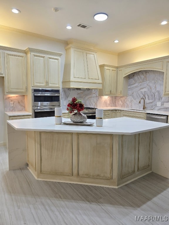 kitchen featuring custom exhaust hood, visible vents, cream cabinetry, and light countertops