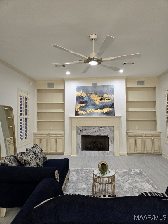 living area featuring visible vents, a fireplace, and a ceiling fan