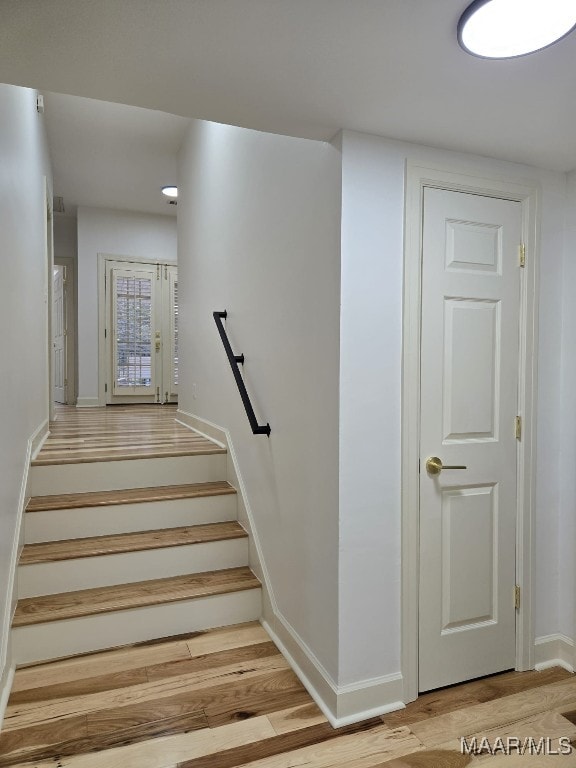 staircase featuring baseboards and wood finished floors