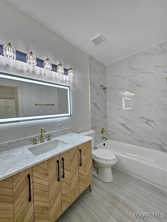 bathroom with visible vents, toilet, tub / shower combination, and vanity