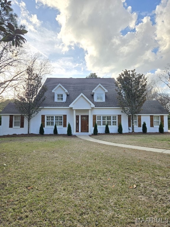 cape cod home with a front yard