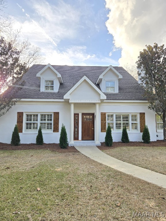 view of front of home featuring a front lawn and a shingled roof