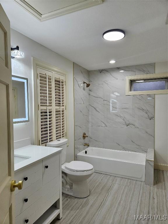 bathroom with toilet, wood finished floors, vanity, and shower / tub combination