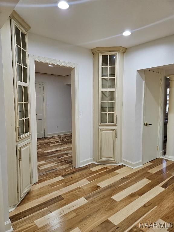 hall with light wood-style flooring, recessed lighting, and baseboards