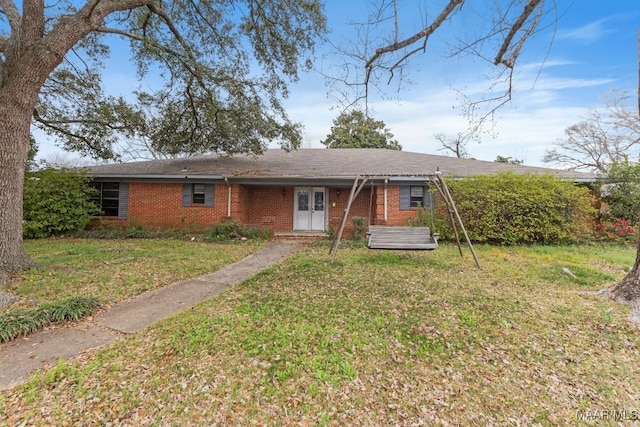 ranch-style home featuring brick siding, french doors, and a front yard