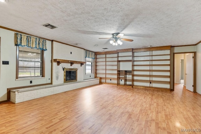 unfurnished living room with visible vents, ceiling fan, ornamental molding, and light wood finished floors