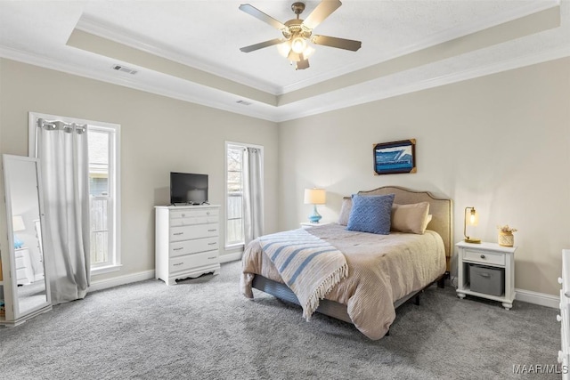 carpeted bedroom with visible vents, a raised ceiling, crown molding, baseboards, and ceiling fan